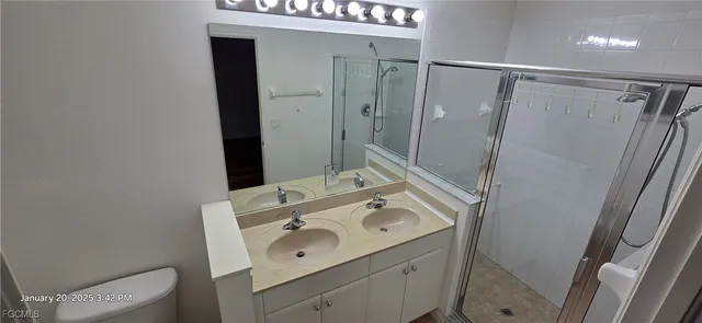 a bathroom with a granite countertop sink a shower and a mirror