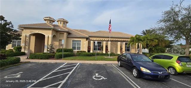 a view of a swimming pool with lawn chairs and iron fence