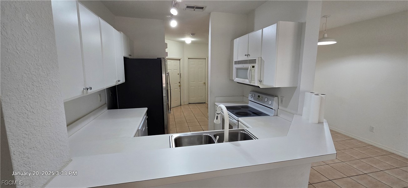8541 Athena Court Lehigh Acres, FL 33971 - Photo 4 of 47 a kitchen with stainless steel appliances a refrigerator sink and stove