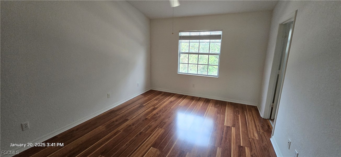 8541 Athena Court Lehigh Acres, FL 33971 - Photo 5 of 47 an empty room with wooden floor and windows