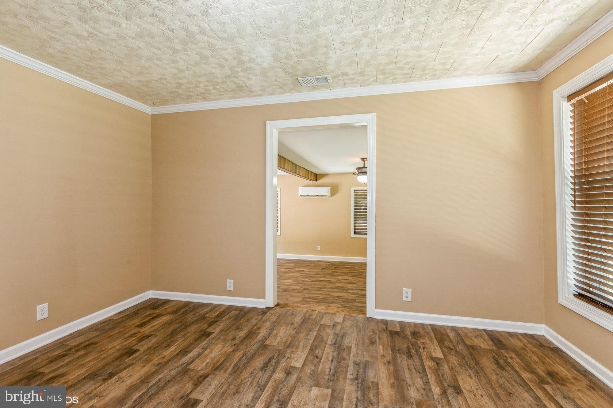 32593 Perryhawkin Road Princess Anne, MD 21853 - Photo 15 of 31 a view of an empty room with wooden floor and a window