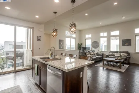 a view of a kitchen and dining room with wooden floor a chandelier