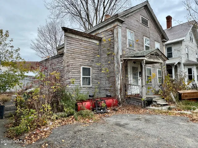 a view of a house with a yard and sitting area