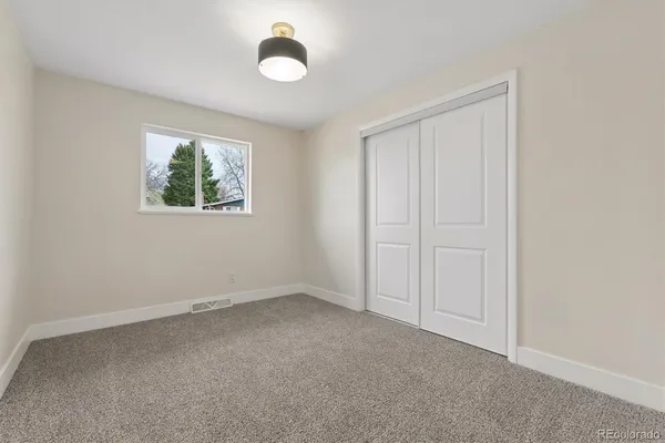 an empty room with windows and closet