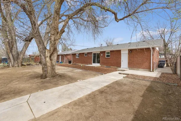 a front view of a house with a tree