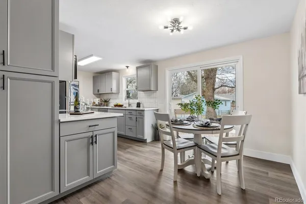 a kitchen with a table chairs refrigerator and cabinets