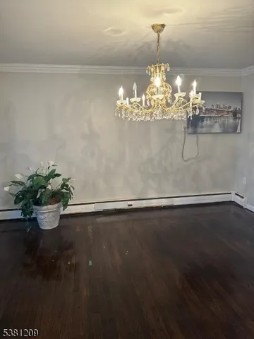 a view of a room with wooden floor vase and flowers
