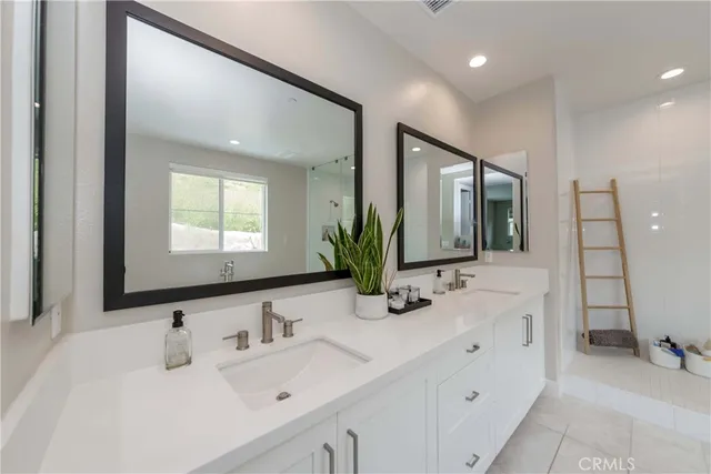 a bathroom with double vanity sinks and a mirror