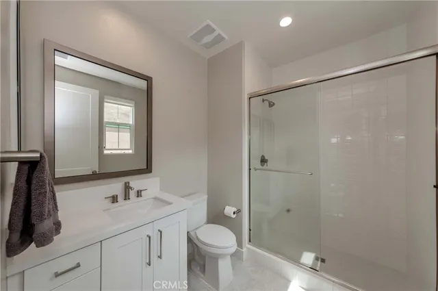 a bathroom with a granite countertop sink toilet and shower