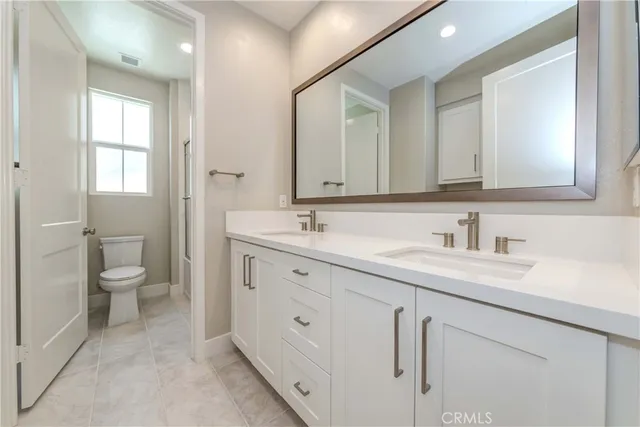 a spacious bathroom with a granite countertop sink mirror and toilet