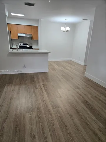 an empty room with wooden floor and a ceiling fan