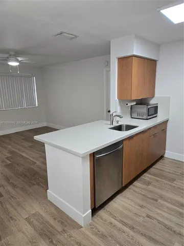 a kitchen with stainless steel appliances a sink cabinets and wooden floor