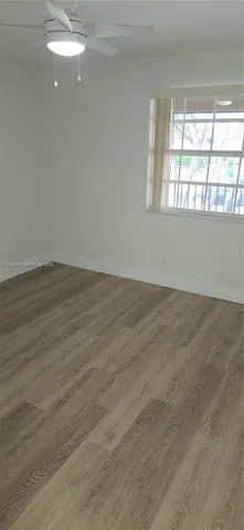 a view of a room with wooden floor and white walls