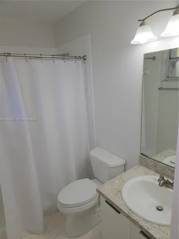 a white toilet sitting next to a bathroom