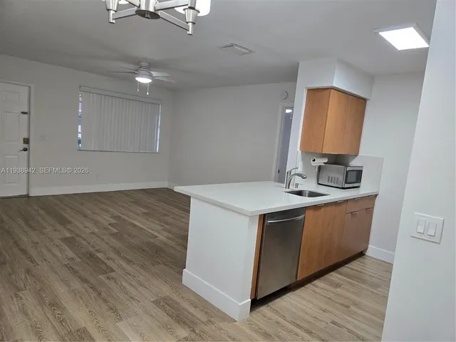 a kitchen with stainless steel appliances granite countertop a sink stove and wooden floor