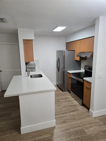 a kitchen that has a sink and a refrigerator