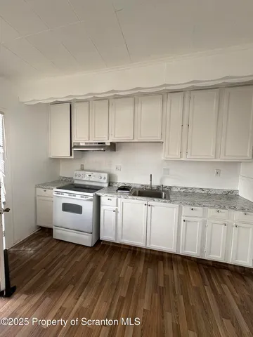 a view of empty room with wooden floor and ceiling fan
