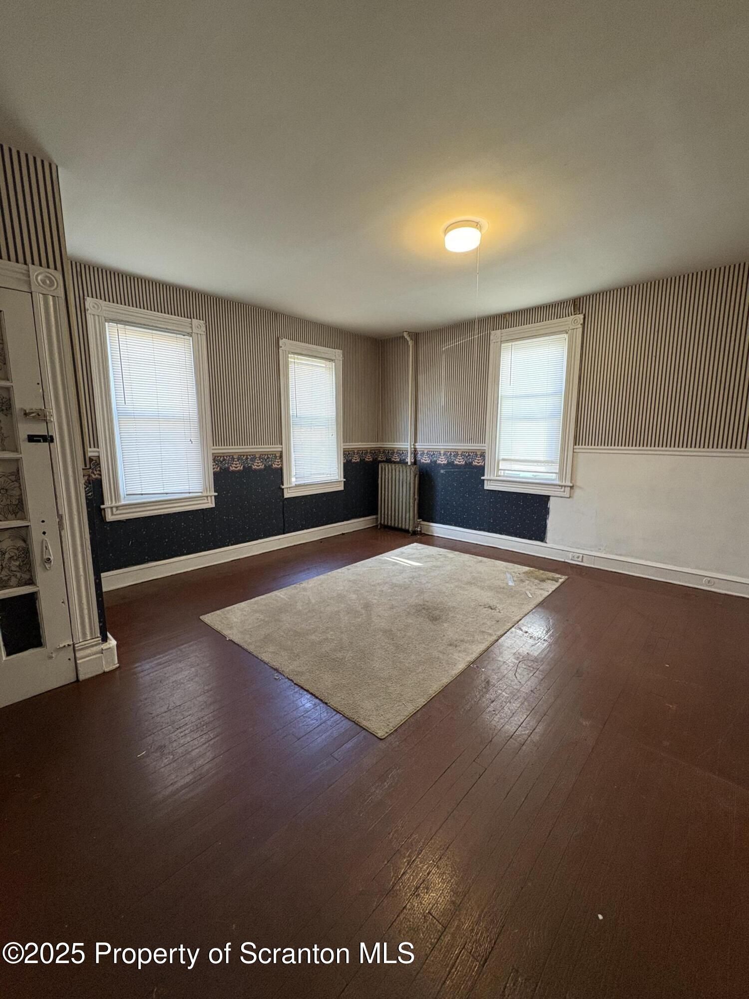 1318 North Washington Avenue Scranton, PA 18509 - Photo 5 of 11 a view of an empty room with window and wooden floor