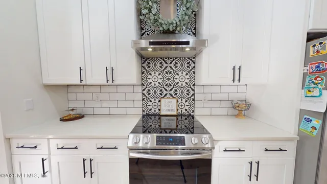 a room with a flat screen tv and a view of kitchen