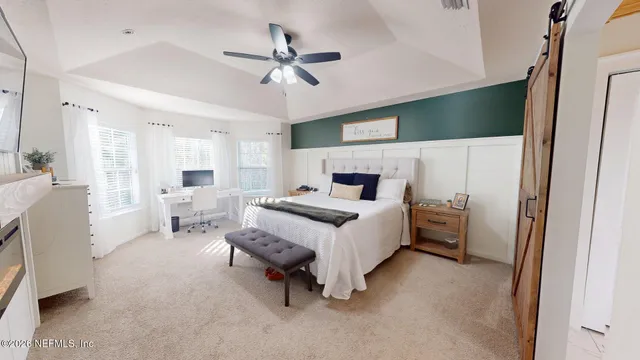 a bedroom with a bed and large windows