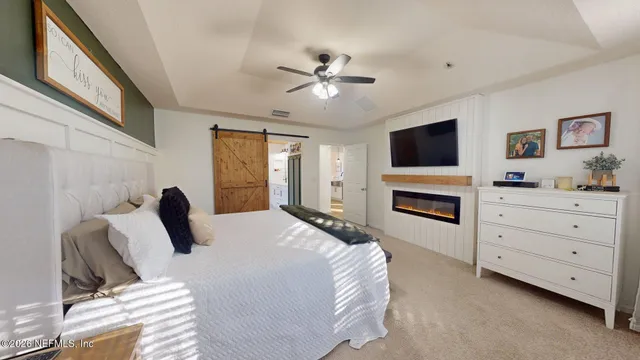 a bedroom with a bed flat screen tv and a fireplace
