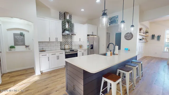 a kitchen with stainless steel appliances kitchen island granite countertop a refrigerator and a sink