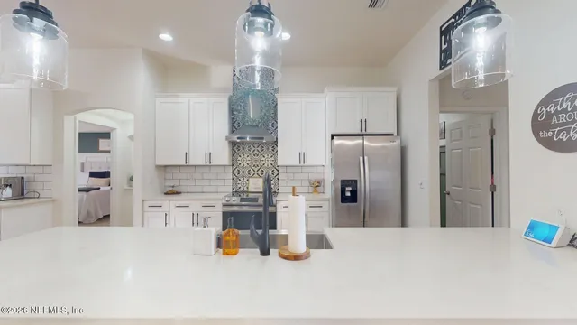 a kitchen with white cabinets and wooden floor