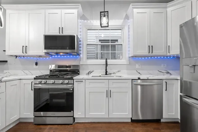 a kitchen with stainless steel appliances a stove a microwave and sink