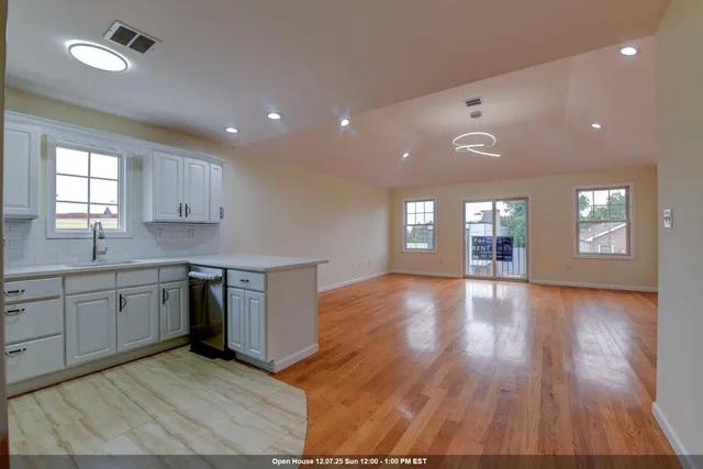 a kitchen with cabinets wooden floor and a window
