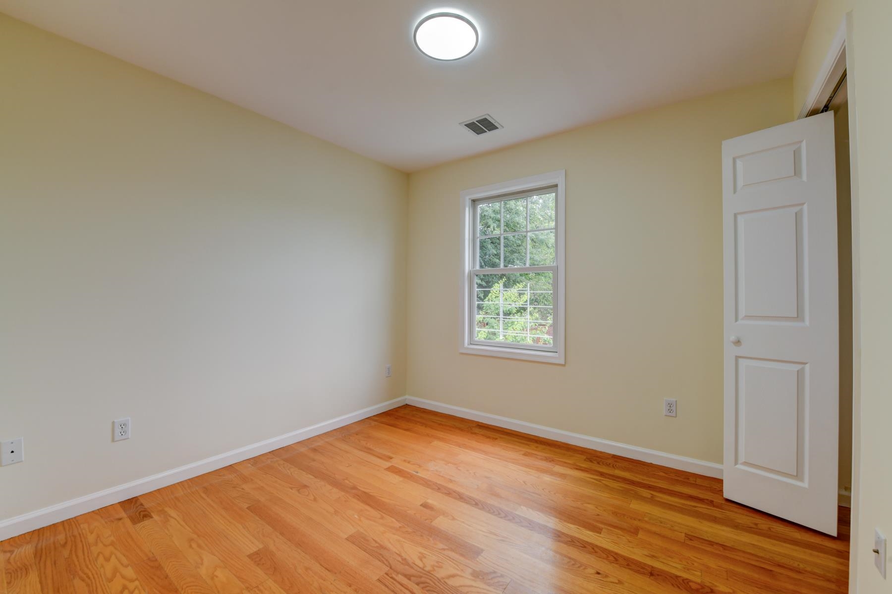 190 Terrace Avenue, Unit 2 Jersey City, NJ 07307 - Photo 16 of 29 an empty room with wooden floor and windows