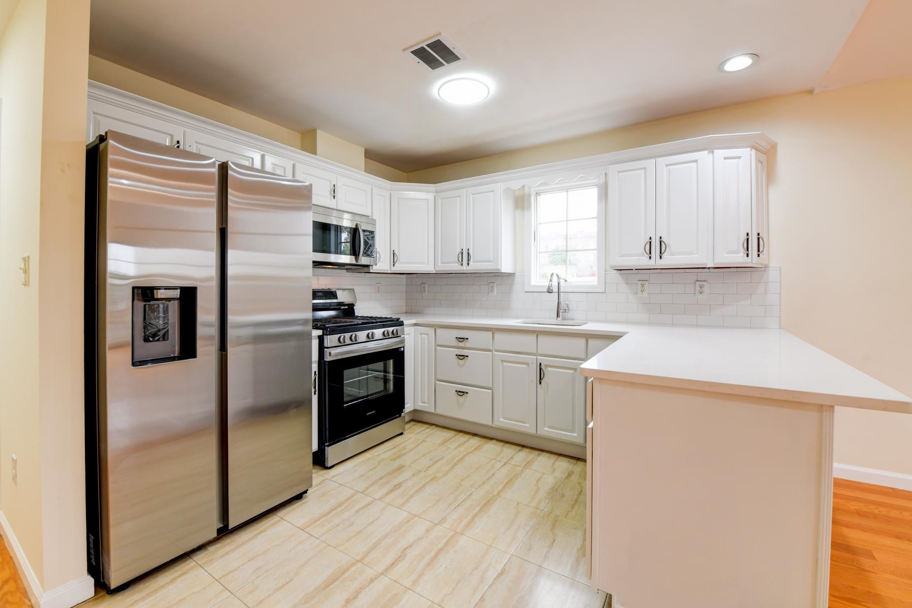 190 Terrace Avenue, Unit 2 Jersey City, NJ 07307 - Photo 4 of 29 a kitchen with a refrigerator a sink and a stove top oven