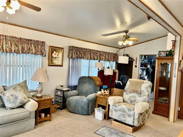 a living room with furniture a flat screen tv and a window