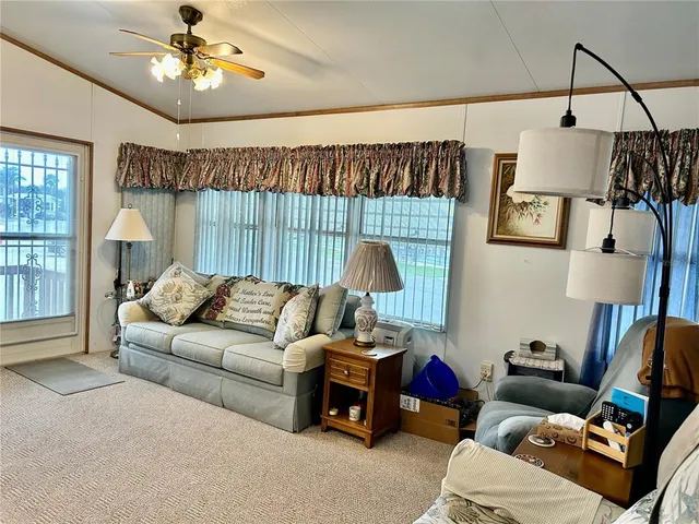 a living room with furniture a chandelier and a flat screen tv