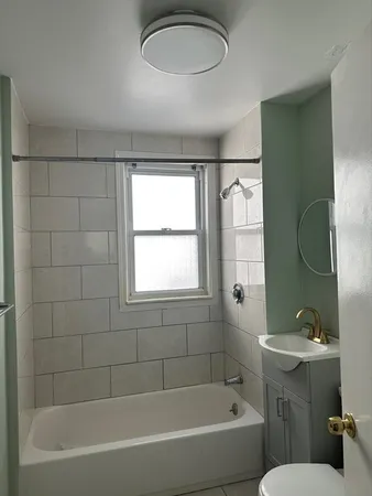 a white bath tub sitting next to a white toilet and a sink