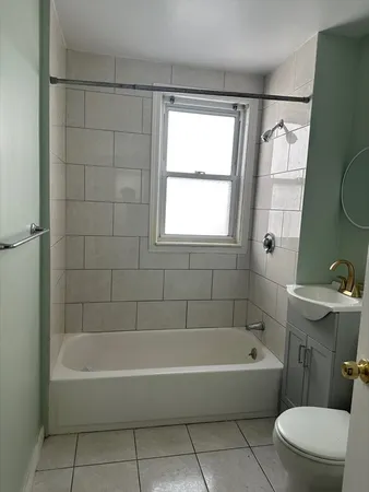 a white bath tub sitting next to a white toilet and a shower