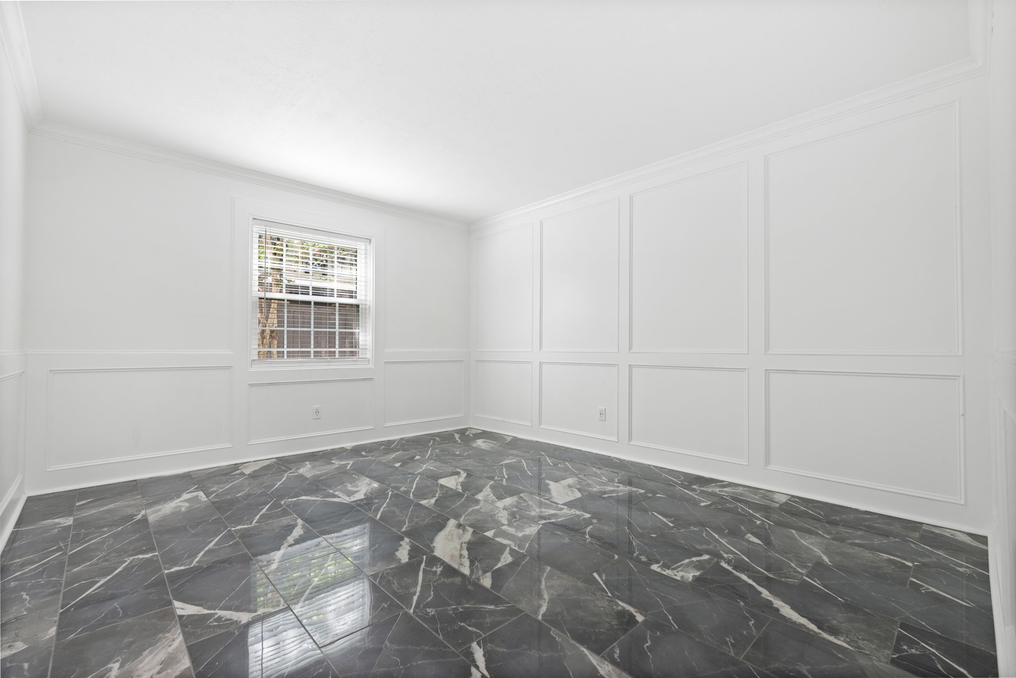 7900 Westheimer Road, Unit 121 Houston, TX 77063 - Photo 17 of 23 Bright room featuring elegant marble flooring and classic white wainscoting, creating a sophisticated and airy atmosphere.