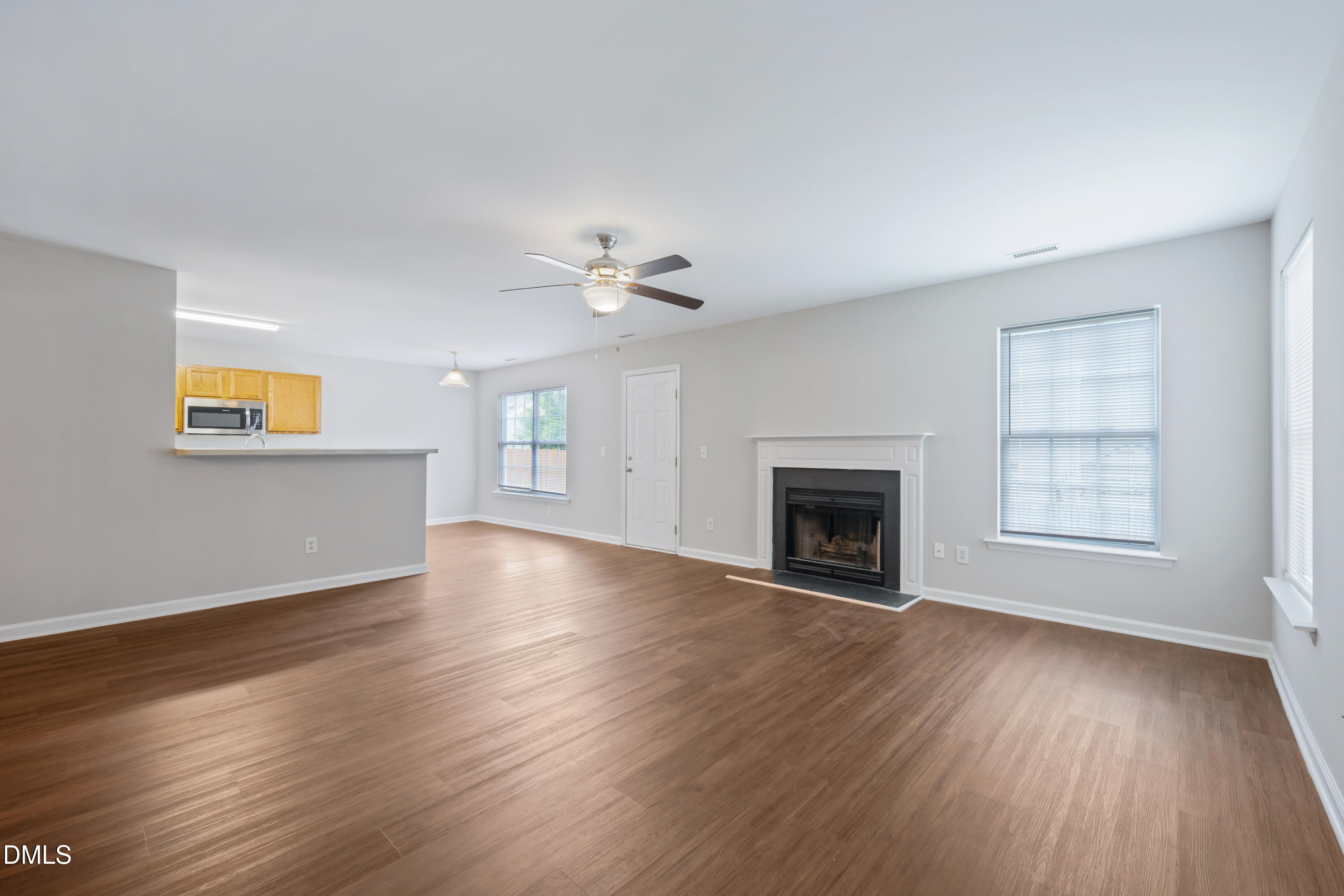 1532 Pebble Ridge Drive Raleigh, NC 27610 - Photo 11 of 40 a view of an empty room with wooden floor fireplace and a window