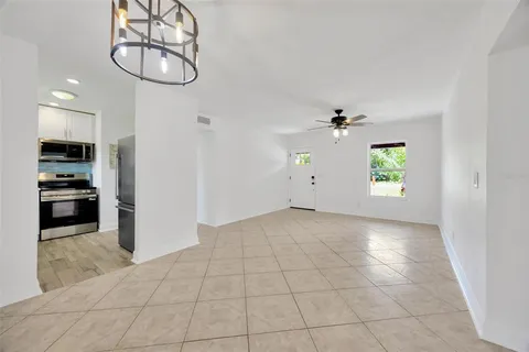 an empty room with windows and ceiling fan