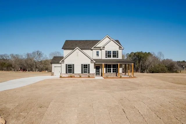 a front view of a house with a yard and trees