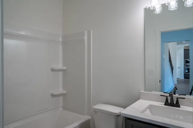 a bathroom with a sink a toilet and a mirror