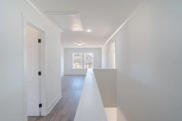 a view of a room with wooden floor and a white door