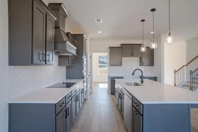a kitchen with a sink a counter top space stainless steel appliances and a center island