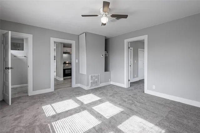 a view of a room with a ceiling fan closet and a bathroom