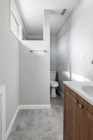 a bathroom with a granite countertop sink and toilet