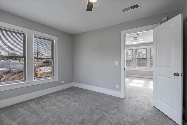 an empty room with windows and cabinet