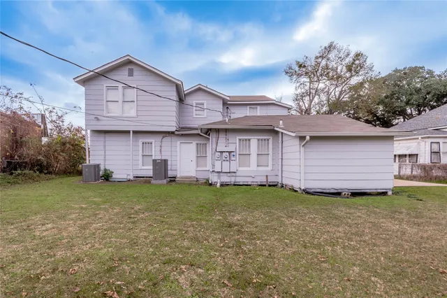 a view of a house with a big yard and large trees