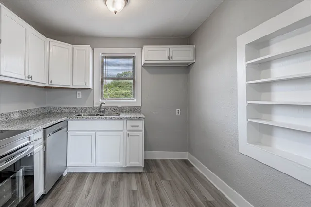 a kitchen with a sink cabinets stainless steel appliances and a window
