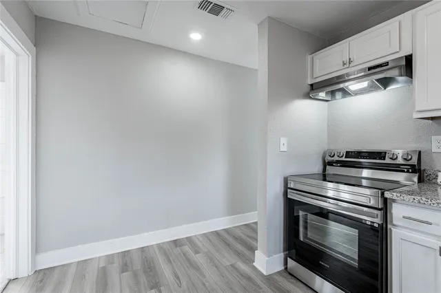 a kitchen with wooden floor and steel stainless steel appliances