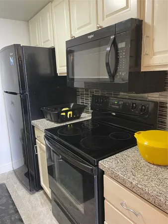 a kitchen with granite countertop stainless steel appliances and wooden cabinets