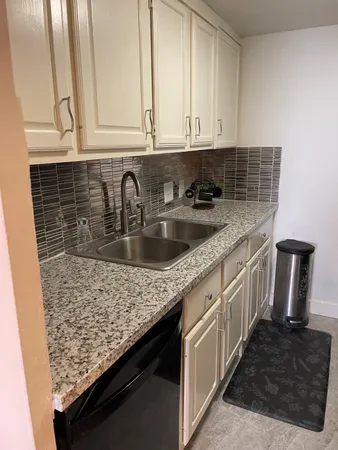 a kitchen with stainless steel appliances granite countertop a sink stove and cabinets